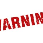 Bright red "WARNING" sign in bold, distressed font indicating urgency and the need for caution.